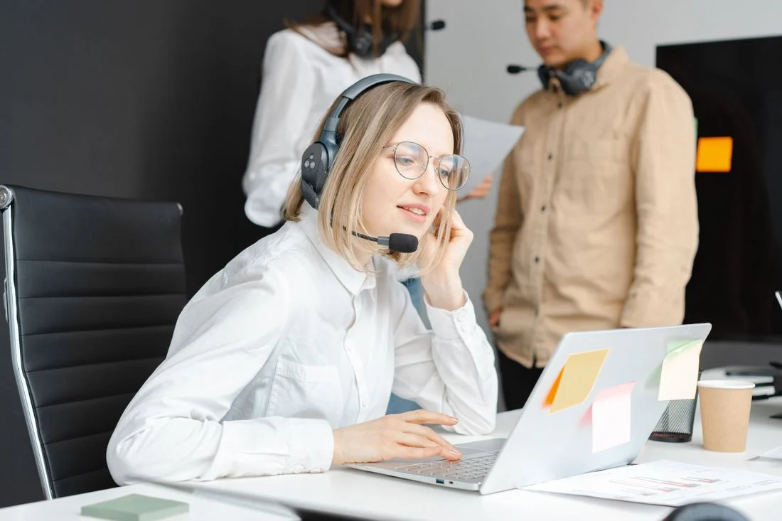 Customer support staff using headsets and laptops